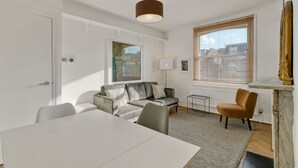 Un soggiorno moderno con un divano bianco, un tavolo da pranzo e un piccolo tavolino.