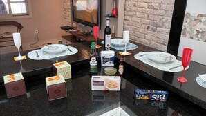 A kitchen counter with various items including a bottle of Andorinha wine, a box of biscuits, and a bottle of Tabasco sauce. - Modern and cozy house with fireplace and heated pool just 50m from the beach. (Imperador - Praia Grande)