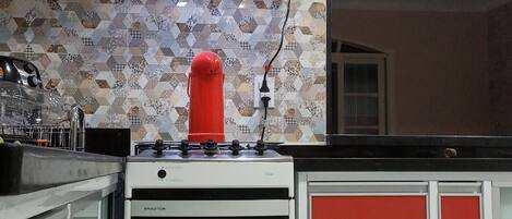 A kitchen with a stove, oven, and red cabinets.