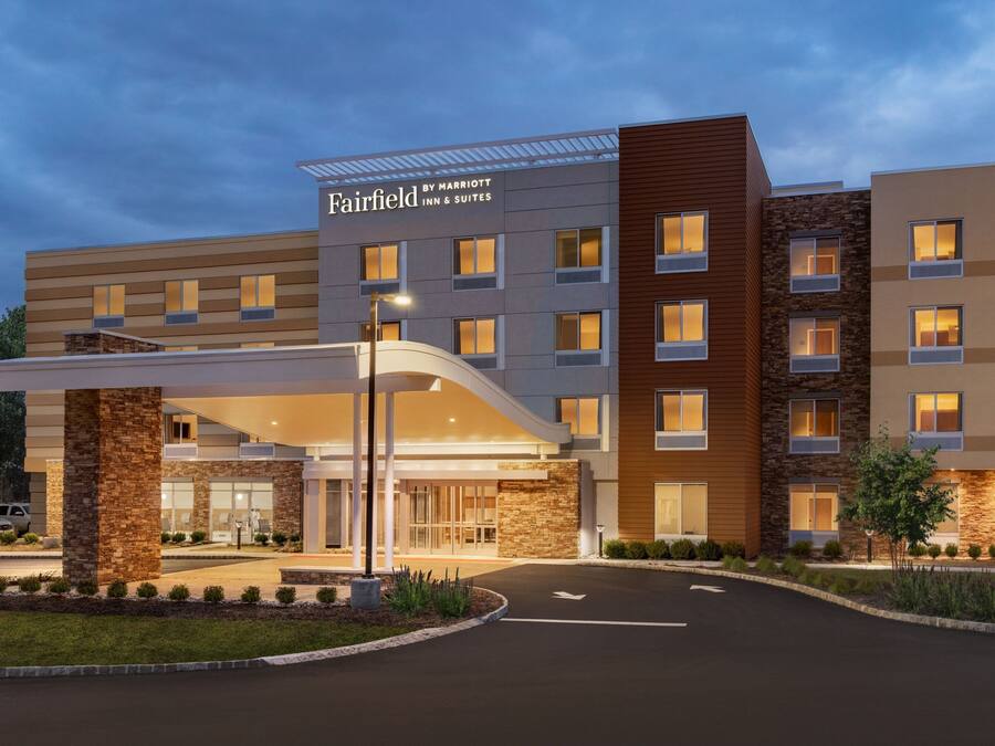 A Fairfield Inn & Suites hotel with a modern design, featuring a covered entrance and multiple floors.