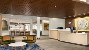A modern hotel lobby with a reception desk, seating area, and a view of the kitchen in the background. - Fairfield Inn & Suites By Marriott Rockaway (Rockaway)