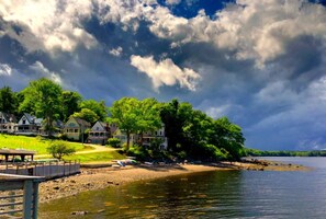 A lakeside property with houses, a dock, and a grassy area. - Arts & Crafts Cottage In Picturesque Bayside, Maine (Northport)