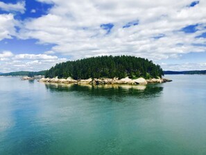 A serene island surrounded by calm waters, with dense forested areas and rocky outcrops. - Arts & Crafts Cottage In Picturesque Bayside, Maine (Northport)