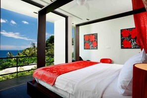 Une chambre moderne avec un grand lit, des touches de rouge et des œuvres d’art accrochées aux murs.