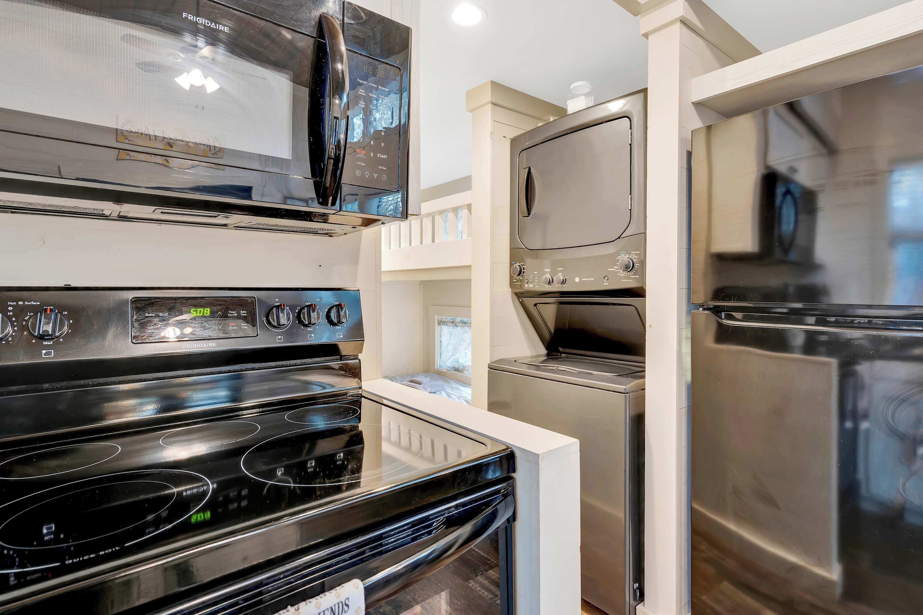 Een moderne keuken met roestvrijstalen apparatuur, waaronder een magnetron, oven en koelkast.