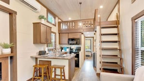 A compact kitchen with wooden cabinets, a central island, and a built-in microwave. - Black Diamond at Mentone with Free Internet! Hikes (Mentone)