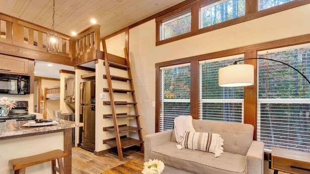 A cozy interior with a wooden staircase, a sofa, and a dining area with a table and chairs. - Black Diamond at Mentone with Free Internet! Hikes (Mentone)