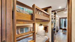 A bunk bed room with a wooden ladder, a small bedside table, and a window with curtains. - Black Diamond at Mentone with Free Internet! Hikes (Mentone)