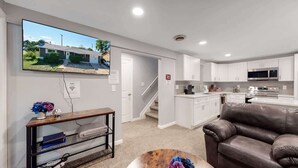 A modern apartment with a living room, kitchen, and a staircase leading to another level. - Spacious Lower Unit Updated Two King Beds in Denver (Denver)