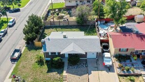 A residential house with a sloped roof, a front yard with a stone pathway, and a driveway. - Spacious Lower Unit Updated Two King Beds in Denver (Denver)