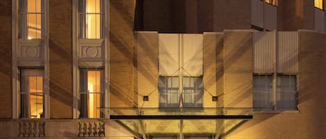 Un edificio de varios pisos con una entrada destacada, ventanas grandes y fachada de ladrillo.