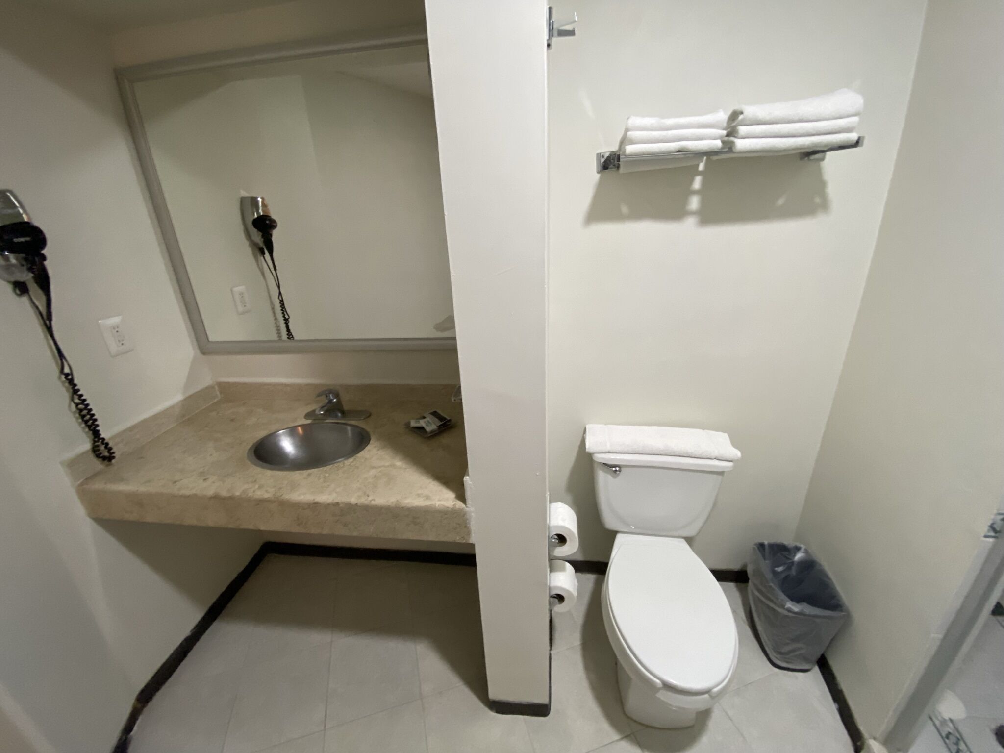 A small bathroom with a sink, toilet, and a towel rack.
