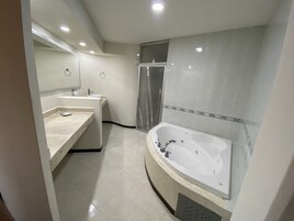Un baño moderno con una bañera grande, un tocador doble y una zona de ducha.