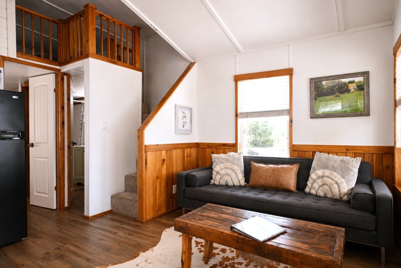 A living room with a sofa, a coffee table, and a staircase leading to an upper level.