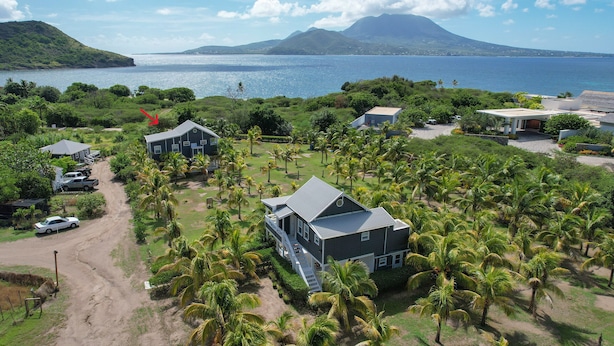 A coastal property with multiple buildings, a dirt road, and palm trees. - Spacious 2 BR cottage with gorgeous views  (Basseterre)