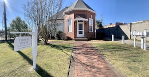 Thomas House features a historic brick facade and a gabled roof, set amidst a well-manicured lawn.