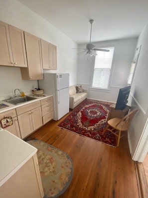 Efficient kitchen space with a dining area, featuring a refrigerator, dining table, and chair.