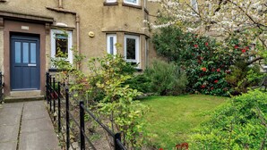 A residential building with a front door, windows, and a garden with various plants and flowers. - Home-from-home; 10 mins from city centre; Free on-street parking; Well-equipped (Edinburgh)