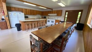 A spacious kitchen with wooden cabinets, a central island, and bar stools.
