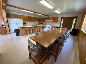 Une cuisine spacieuse avec des meubles en bois, un îlot central et des tabourets de bar.