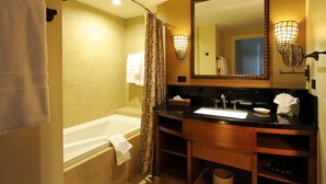 A bathroom with a bathtub, a sink, a mirror, and a towel rack. - Disney Aulani Deluxe Oceanview Studio Villa! (Kapolei)