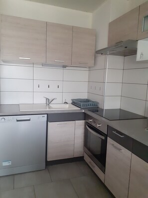 A modern kitchen with a dishwasher, oven, and a sink. - APARTMENT IN SAINT CYPRIEN, OFF-SEASON: 250 € PER WEEK (Saint-Cyprien)