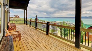 A wooden deck with benches overlooking a coastal view.