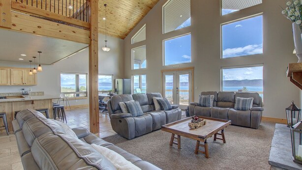 A spacious living area with leather sofas, a wooden coffee table, and large windows offering ocean views.