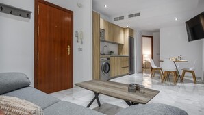 Un apartamento moderno con sala de estar, kitchenette y comedor.