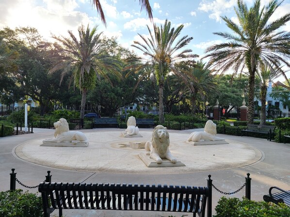 A circular plaza with four lion statues, surrounded by benches and palm trees. - Best Location in Hyde Park, South Tampa (Tampa)