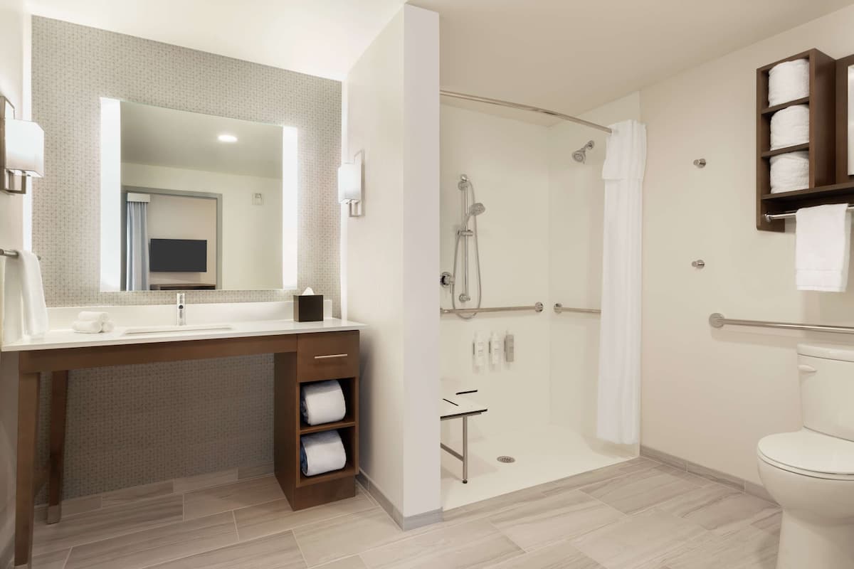 Un baño moderno con ducha, inodoro y tocador.
