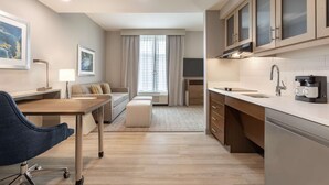 Una cocina moderna con comedor, un sofá y un escritorio con silla.