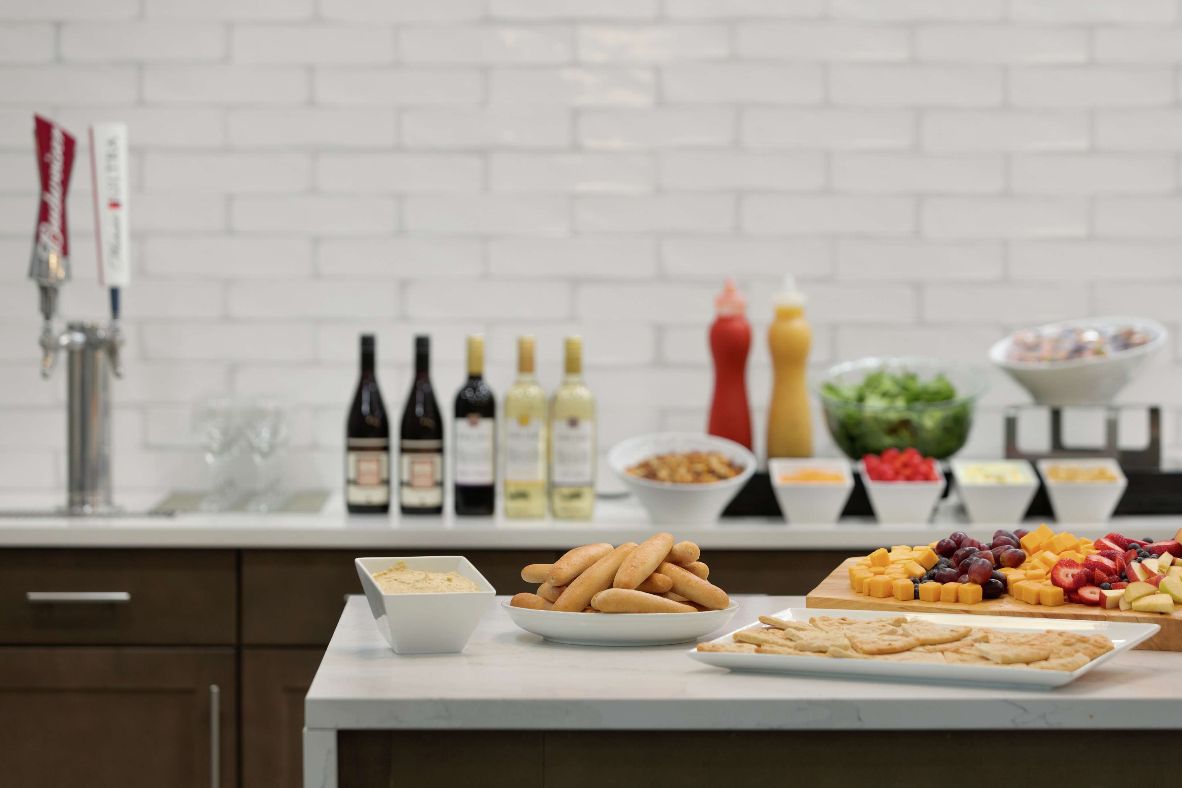 A buffet table with various food items and condiments.
