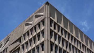 A building with a geometric facade and a clear blue sky in the background.
