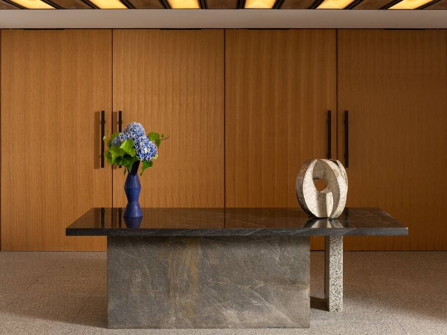 A reception desk with a vase of flowers and a decorative sculpture.