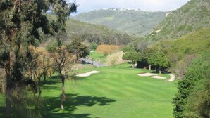 A golf course with sand bunkers, trees, and a hilly landscape in the background. - Walk to Strands Beach - updated, comfortable and quiet (Dana Point)