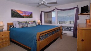 A bedroom with a bed, a nightstand, a dresser, a ceiling fan, a window with curtains, and a television on a stand. - Columbine Slopeside, Ski in/out, Hot tub (Crested Butte)