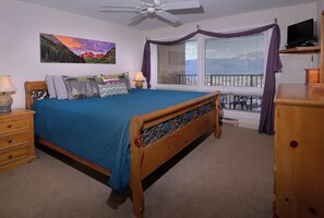 A bedroom with a bed, a nightstand, a dresser, a ceiling fan, a window with curtains, and a television on a stand. - Columbine Slopeside, Ski in/out, Hot tub (Crested Butte)