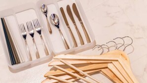 A set of silverware and wooden utensils in a plastic container. - ORANGE (Sapporo)