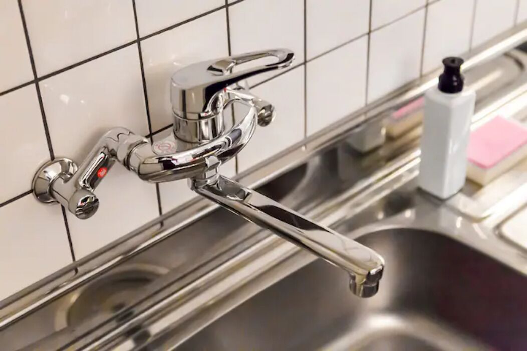 A modern kitchen with a stainless steel sink and a chrome faucet.