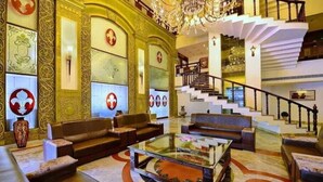 A grand lobby with ornate wall designs, a staircase, and a chandelier. - The Avalon Durg (Durg)