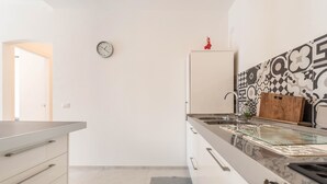 A modern kitchen with a clock, a refrigerator, and patterned tiles. - Appartamento "Le Cementine" with Lake View, Mountain View, Wi-Fi, A/C & Terrace (Vesio, Tremosine sul garda)