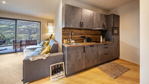 A modern kitchen with grey cabinets, a wooden countertop, and a built-in stove.