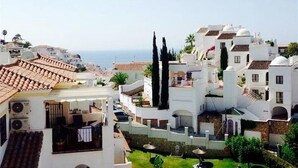 A coastal town with white buildings, terracotta roofs, and a view of the sea. - Apartment Valparaiso - Burriana Beach with Sea View, Pool, Wi-Fi, A/C & Terraces (Nerja)