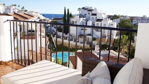 A balcony with a pool, white buildings, and a clear view of the sea. - Apartment Valparaiso - Burriana Beach with Sea View, Pool, Wi-Fi, A/C & Terraces (Nerja)