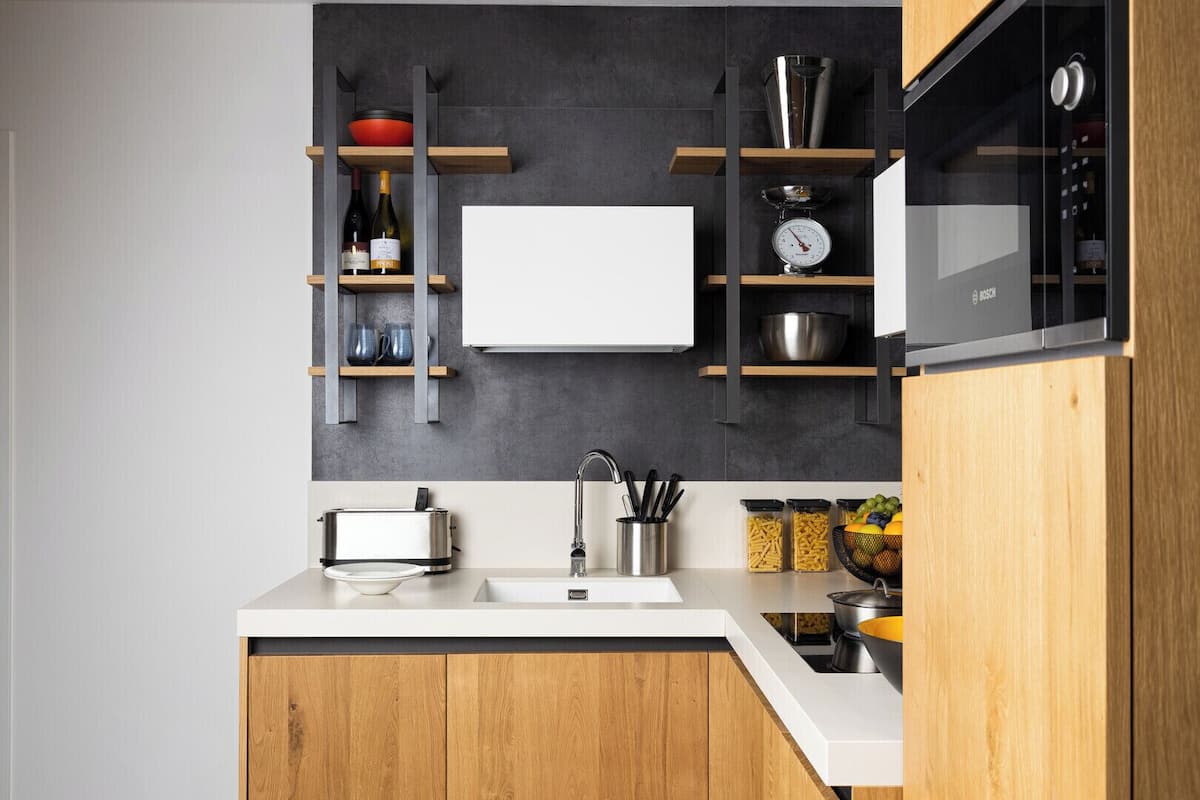 Een moderne keuken met een broodrooster, gootsteen en houten kastjes.