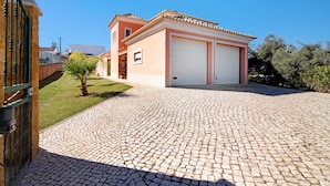 Um imóvel residencial com entrada pavimentada, garagem e um pequeno jardim.