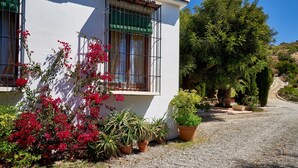 A building with a white exterior, a balcony with metal railings, and potted plants. - Country House 'Santa Matilde Málaga' with Sea Views, Wi-Fi and Air Conditioning (Málaga)