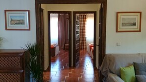 A hallway with a wooden floor, a sofa, and a bed with curtains. - Country House 'Santa Matilde Málaga' with Sea Views, Wi-Fi and Air Conditioning (Málaga)