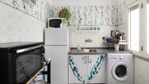 Cocina compacta con microondas, horno, fregadero y lavadora.